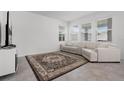 Inviting living room with neutral tones, a large area rug, a comfortable sofa, and plenty of natural light at 6458 Pine Warbler Way, St Cloud, FL 34771