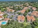 Aerial view of condo complex, surrounded by lush greenery, features a community pool, and ample parking at 698 Roaring Dr # 382, Altamonte Springs, FL 32714