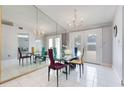 Elegant dining room with mirrored walls, a chandelier, and stylish seating for eight at 7750 Murcott Cir, Orlando, FL 32835