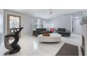 Inviting living room showcasing a white tile floor, modern furniture, and ample natural light at 7750 Murcott Cir, Orlando, FL 32835