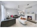 Bright living room featuring a decorative fireplace, modern furniture, and white tile floors at 7750 Murcott Cir, Orlando, FL 32835