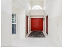 Bright foyer with red double doors and a transom window, offering a welcoming and grand entrance to the home at 8801 Crayson Ct, Kissimmee, FL 34747