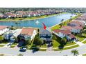 Aerial shot showcases this two-story home's backyard and pond, nestled within a serene community with lush landscaping at 10427 Royal Cypress Way, Orlando, FL 32836