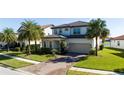 Beautiful two-story home with a well-maintained lawn and a brick driveway leading to an attached two-car garage at 10427 Royal Cypress Way, Orlando, FL 32836