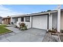 A single-story home featuring a white exterior with gray trim, an attached single car garage and newly landscaped yard at 1184 Calanda Ave, Orlando, FL 32807