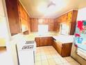 Functional kitchen boasts classic cabinetry, white appliances and a window for natural light at 1403 N Fern Creek Ave, Orlando, FL 32803