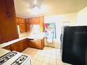 Efficient kitchen layout with abundant wood cabinets, white countertops, and access to outdoor space at 1403 N Fern Creek Ave, Orlando, FL 32803