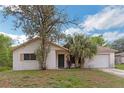 Charming single-story home featuring an attached garage and mature landscaping in the front yard at 1421 Summit Hill Dr, Deltona, FL 32725