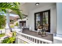 Charming front porch featuring rocking chairs, warm colors, decorative accents, and beautiful, shaded plants at 14213 Southern Red Maple Dr, Orlando, FL 32828
