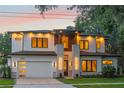 Picturesque two-story house with ambient lighting and meticulous landscaping, set against a colorful twilight sky at 1620 S Eola Dr, Orlando, FL 32806