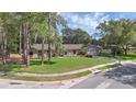 Inviting one-story brick home with lush lawn, mature trees, and a serene neighborhood setting at 223 Royal Oaks Cir, Longwood, FL 32779