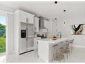 Modern kitchen featuring stainless steel appliances, island with counter seating and marble floors at 2446 Greenway, Sanford, FL 32771