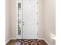 Bright entryway featuring a white door with decorative glass and a patterned rug on hardwood floors at 337 Meadow Pointe Dr, Haines City, FL 33844