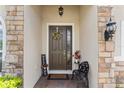 Inviting front door with stone accents, a decorative wreath, and a charming welcome sign, creating a warm entry at 337 Meadow Pointe Dr, Haines City, FL 33844