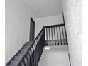View of the stairway with dark wood handrail leading to the condo entrance at 4403 S Semoran Blvd # 3, Orlando, FL 32822