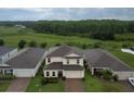 Aerial view of a home backing up to a large green space, surrounded by mature trees and other houses at 565 Ogelthorpe Dr, Davenport, FL 33897