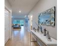 Long hallway leading to the living area featuring tile floors and modern decor at 565 Ogelthorpe Dr, Davenport, FL 33897
