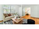 Bright living room featuring hardwood floors, neutral decor, modern furnishings, and an open layout with abundant natural light at 600 Sheridan Blvd, Orlando, FL 32804