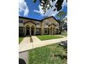 Inviting townhome showcasing a well-maintained lawn and convenient sidewalk access at 6013 Scotchwood Gln # 20, Orlando, FL 32822