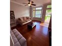 Cozy living room with hardwood floors, a ceiling fan and large windows at 6013 Scotchwood Gln # 20, Orlando, FL 32822