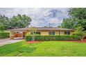 Charming single-story home featuring a manicured lawn and welcoming covered entryway at 6430 Yellowstone St, Orlando, FL 32807