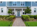 Welcoming front entrance with a brick pathway, lush landscaping, and a stylish blue front door at 8427 Modiano St, Orlando, FL 32827
