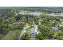 Stunning aerial view of property with pool, lush greenery, and a serene lake nearby at 102 Linda Ln, Lake Mary, FL 32746
