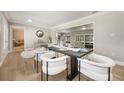 Elegant dining area with modern table setting, contemporary chairs, and wood-look tile flooring at 102 Linda Ln, Lake Mary, FL 32746