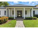 Welcoming front entrance with brick walkway, manicured landscaping and covered entry with grand white columns at 10209 Trout Rd, Orlando, FL 32836