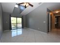Living room with high ceilings, fan, gray walls, and sliding door to balcony at 1131 S Pine Ridge Cir # 1, Sanford, FL 32773