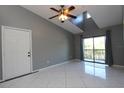 Living room with high ceilings, fan, gray walls, and sliding door to balcony at 1131 S Pine Ridge Cir # 1, Sanford, FL 32773