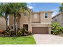 Charming two-story home with a brick driveway, well-manicured lawn and beautiful landscaping at 12286 Regal Lily Ln, Orlando, FL 32827