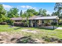 Attractive home with mature landscaping and a convenient covered carport at 1250 Tangerine Ct, Eustis, FL 32726