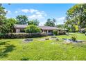 Beautiful home featuring a well-manicured lawn, covered carport, and mature landscaping at 1250 Tangerine Ct, Eustis, FL 32726
