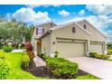 Beautiful two-story home with well-manicured lawn and garden beds leading to a three-car garage at 1356 Scarlet Oak Loop, Winter Garden, FL 34787
