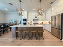 Spacious kitchen features a large center island with seating, modern appliances, and stylish pendant lighting at 13617 Haulover Beach Ln, Orlando, FL 32827