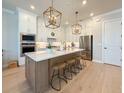 Well-lit kitchen with stainless steel appliances, a central island with barstool seating, and ample counter space at 13617 Haulover Beach Ln, Orlando, FL 32827