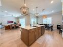 Open-concept kitchen with a spacious island, modern appliances, and seamless flow to the living and dining areas at 13617 Haulover Beach Ln, Orlando, FL 32827