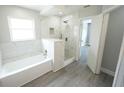Bright bathroom featuring a tub, shower, and marble surround at 14308 Abington Heights Dr, Orlando, FL 32828