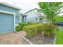 Charming single-story home with a brick driveway, lush landscaping, and a welcoming blue exterior at 1529 Chelsea Manor Cir, Deland, FL 32724