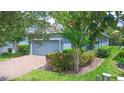 Charming single-story home with a brick driveway, lush landscaping, and a welcoming blue exterior at 1529 Chelsea Manor Cir, Deland, FL 32724