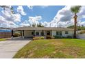 Charming single story home with a car port and lovely landscaping on a sunny day at 1801 Palm Ln, Orlando, FL 32803