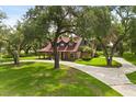 Sprawling property featuring a long driveway, lush landscaping, and mature trees at 1815 Big Oak Ln, Kissimmee, FL 34746