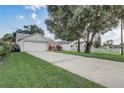 A wide shot of the front of the house with a driveway, landscaping, and picket fence at 1821 Geigel Ave, Orlando, FL 32806