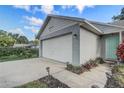 A gray house with a white garage door, some foliage, and a side front entrance at 1821 Geigel Ave, Orlando, FL 32806