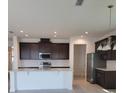 Spacious kitchen with stainless steel appliances, subway tile backsplash, an island with bar seating, and modern lighting at 1855 Church Lake St, Groveland, FL 34736