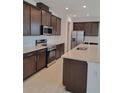 Modern kitchen features stainless steel appliances, granite countertops, tile backsplash, and dark wood cabinetry at 1855 Church Lake St, Groveland, FL 34736