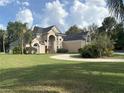 Spacious home with a circular driveway, manicured lawn, and beautiful, mature trees at 1865 S Tanner Ct, Deltona, FL 32738