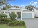 Charming single-story home with a gray brick driveway, a two-car garage, and a cozy front porch at 1962 Flora Pass Pl, Kissimmee, FL 34747