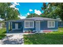 Charming blue home with a well-maintained front yard and a convenient carport at 207 Kay St, Auburndale, FL 33823